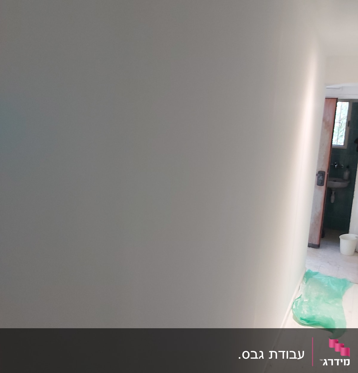 קיר גבס צבוע בלבן עם רצפת עץ